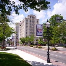 Street view of Mansfield, Ohio with trees and commercial buildings near residential areas, showcasing Mansfield real estate.