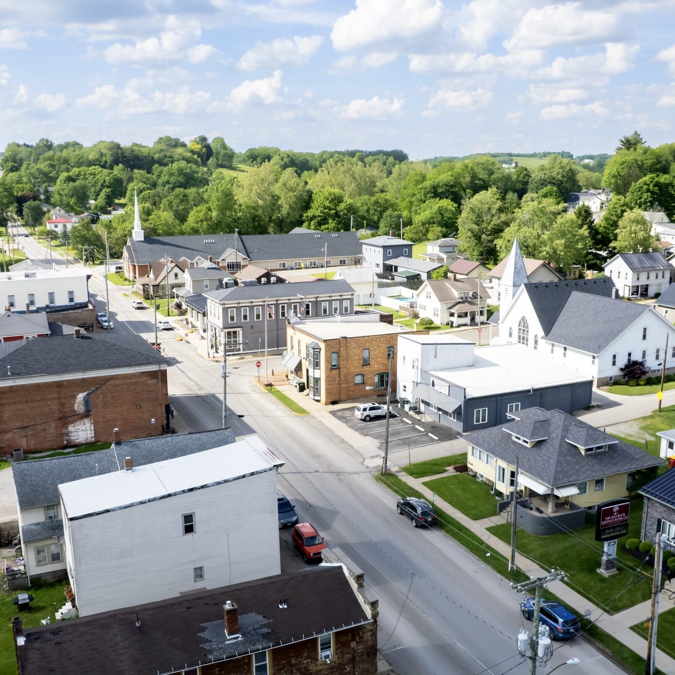 Aerial photo of Fredericksburg, Ohio neighborhoods and church steeple, highlighting small-town homes for sale.